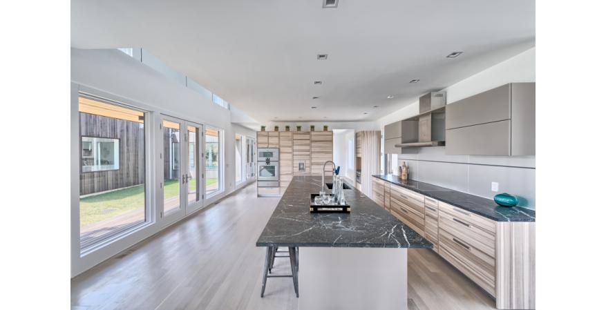 The No. 16 kitchen offers ample space for gathering, along with a work triangle and sleek Gaggenau appliances for cooking enthusiasts. Other features include textured granite countertops and an aluminum backsplash.
