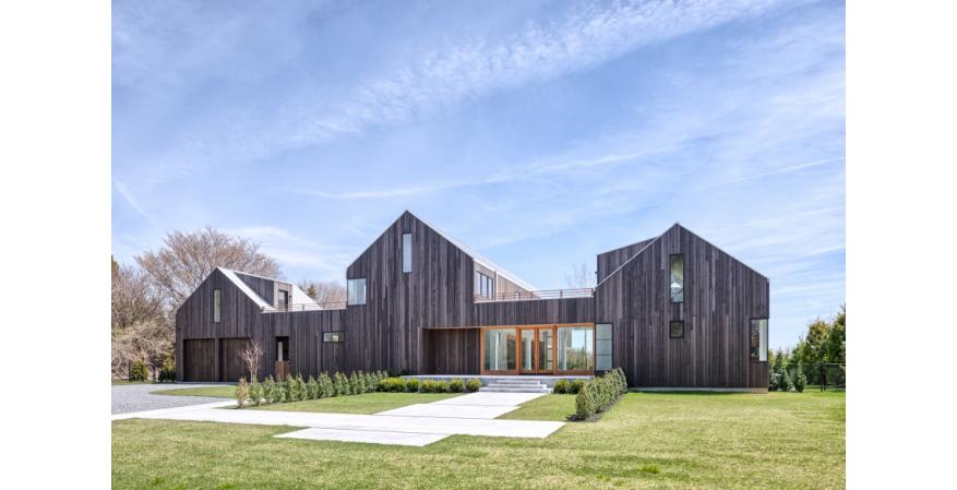 The exterior of No. 16 Fieldview Lane. Both homes offer the forms and rustic tone of the area's farmhouse stylings, but with a modern edge. The pair of residences complement each other but offer distintive looks and layouts.