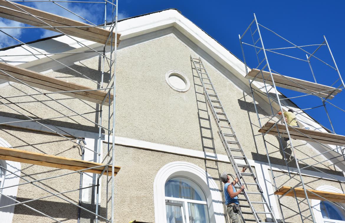 House builder working on stucco exterior
