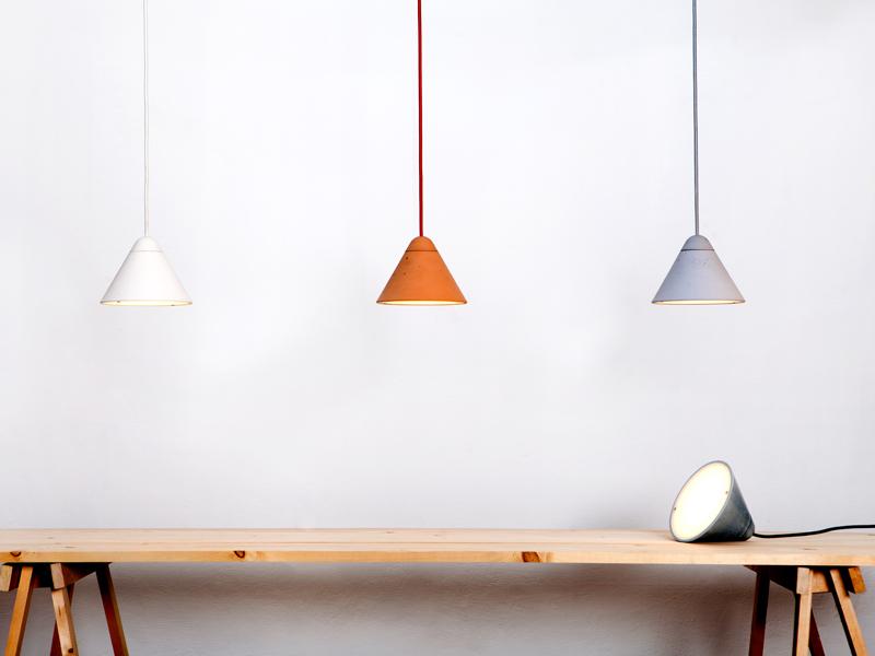 Three of Studio Itai Bar-On’s Bullet lighting Collection, a line of hand-cast concrete lighting that is available in different sizes, tones, and finishes.