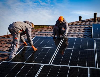 Builders installing rooftop solar panels