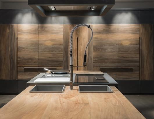 Seeking a stand-out material for its new line of products, Italian cabinet brand Toncelli turned to an 800-year-old Serbian beechwood whose well-seasoned personality will resist water absorption and abrasion, the company says.  The wood is being used for the company's Essence line. While the fossil beechwood makes up the majority of the kitchen, titanium steel is used for the cooking surface.