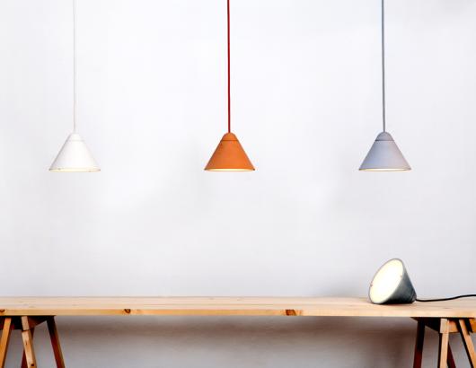 Three of Studio Itai Bar-On’s Bullet lighting Collection, a line of hand-cast concrete lighting that is available in different sizes, tones, and finishes.